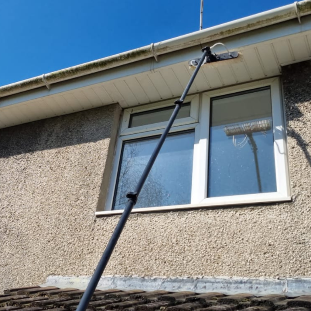 An image of a dirty fascia and soffit cleaned by a water fed pole